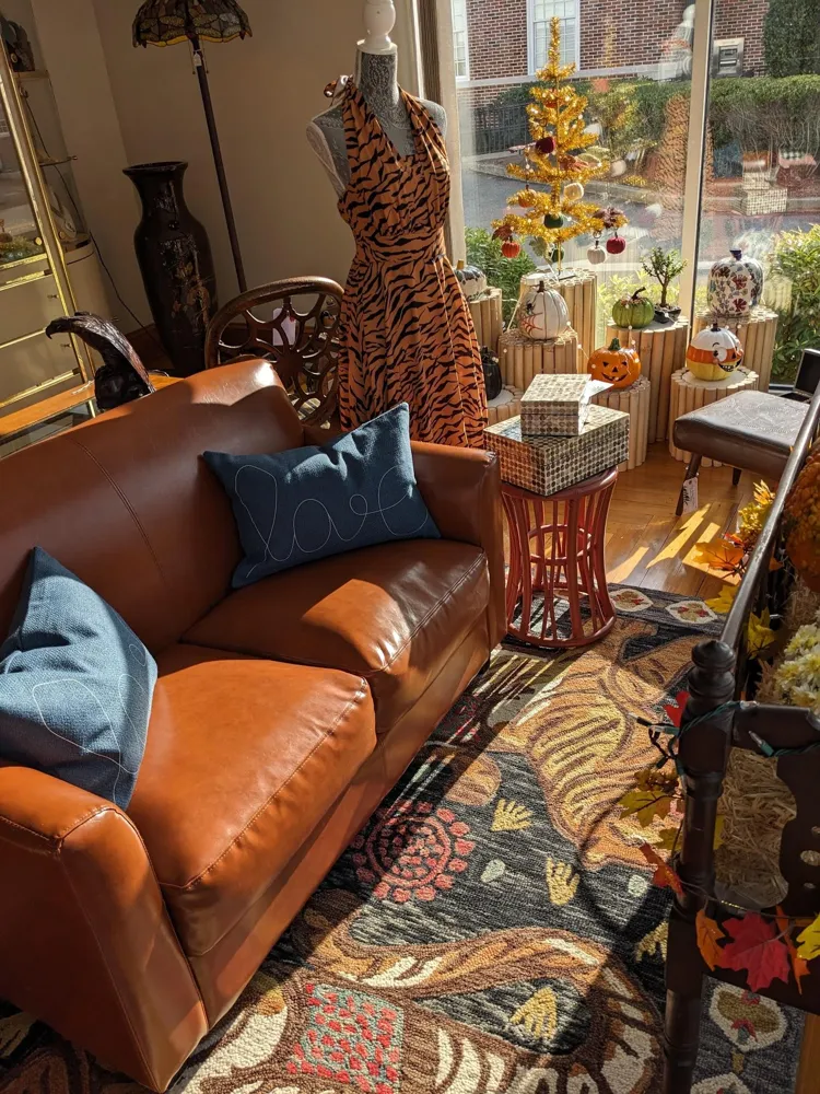 Orange leather sofa with a tiger rug and vintage dress form