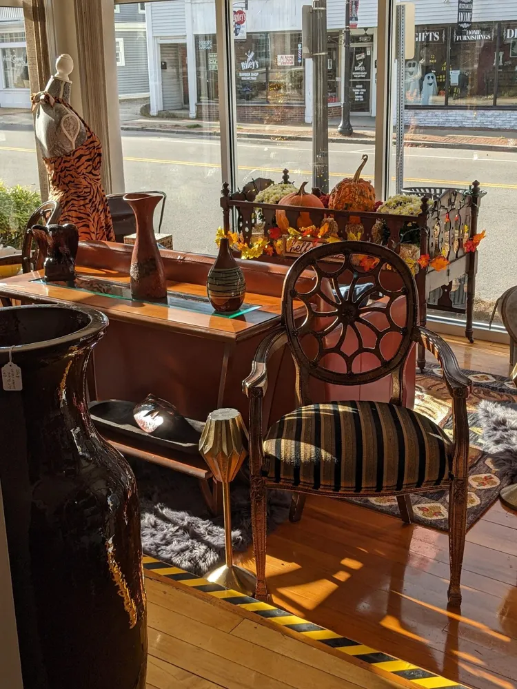 Striped antique chair and wooden console by the front windows
