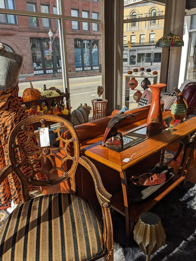 Carved chair, orange pottery and a wood table with Main Street behind